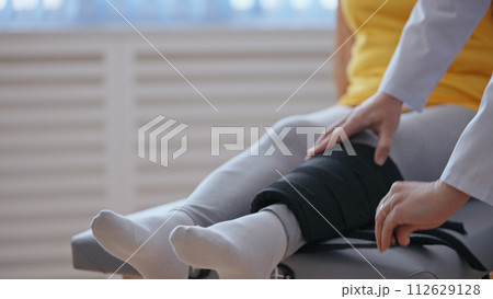 A doctor removes a cast from a patient's leg, signifying successful treatment A doctor removes a cast from a patient's leg, signifying successful treatment 112629128