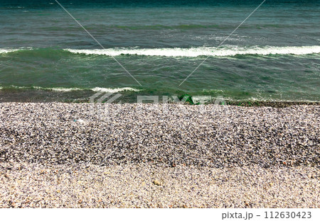 Sea green aquamarine waves line sunny seashell beach. wave ocean foam. 112630423