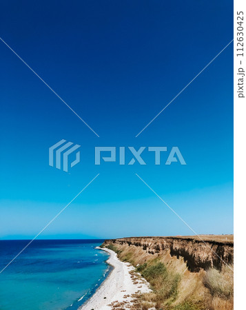 cliff sea blue aquamarine waves line sunny beach. Soft wave of ocean foam. cliff sea blue aquamarine waves line sunny beach. Soft wave of ocean foam. 112630425