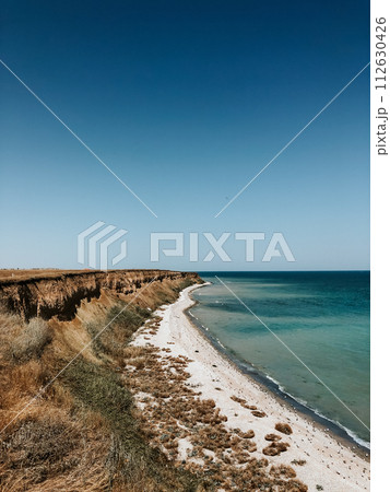 cliff sea blue aquamarine waves line sunny beach. Soft wave of ocean foam. cliff sea blue aquamarine waves line sunny beach. Soft wave of ocean foam. 112630426