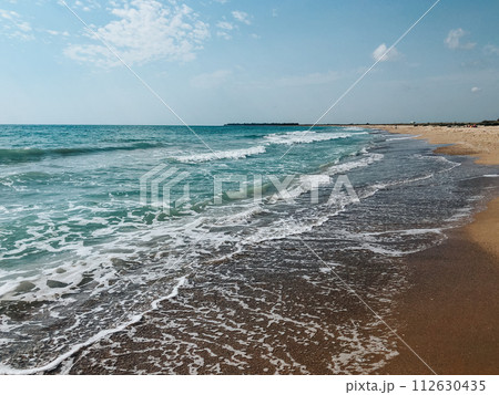 Sea blue aquamarine waves line sunny sand beach. Soft wave of ocean foam. 112630435