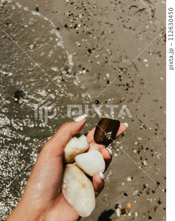woman hand holding stones. Multicolored seashells Black Sea Romania. woman hand holding stones. Multicolored seashells Black Sea Romania. 112630450
