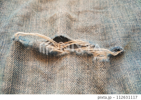 Close-up of ripped jeans with pile, wear and tear of clothes 112631117