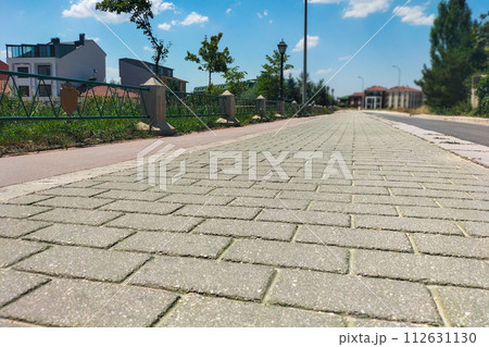 Pavement with the texture of a brick wall knocked out during the laying of hot asphalt going into the distance, with perspective and close-up Pavement with the texture of a brick wall knocked out during the laying of hot asphalt going into the distance, with perspective and close-up 112631130