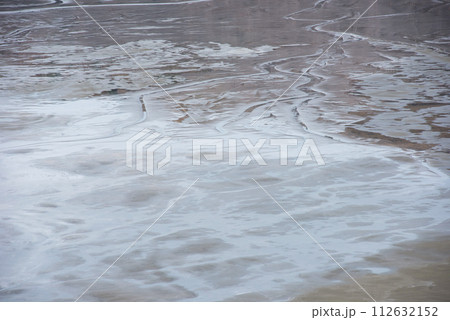 Muddy waters in a decantation pond. Toxic residuals from a copper mine decating in a settling basin 112632152