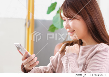 スマートフォンを操作する若い女性 112633897