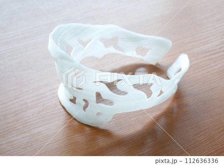 Neck splint corset prosthesis langet printed on a 3D printer from molten plastic. Medical orthosis, fixator, plastic overlay created on 3D printer. New modern medical 3D printing technologies 112636336