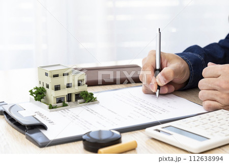 不動産売買の契約書を記入する男性の手 不動産売買の契約書を記入する男性の手 112638994