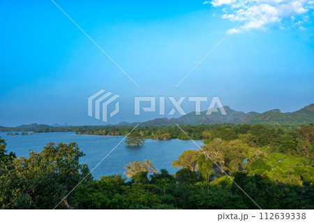 Serene Lake and Greenery under Blue Sky at Heritance Kandalama. Serene Lake and Greenery under Blue Sky at Heritance Kandalama. 112639338
