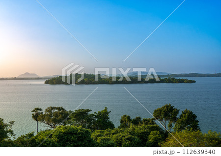 Serene Lake and Greenery under Blue Sky at Heritance Kandalama. 112639340