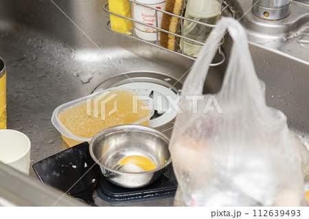 汚れ物がたまったキッチンのシンク 112639493