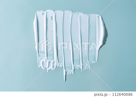 Stroke of white cream on a blue background. 112640086
