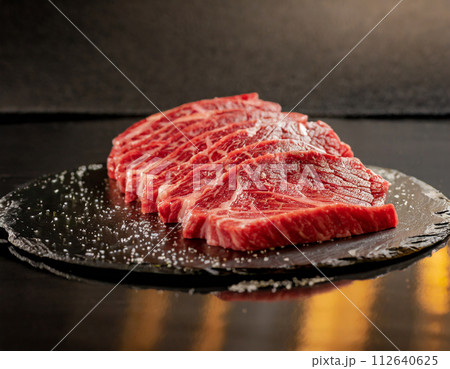 プレートの上のおいしそうな黒毛和牛の新鮮な生肉（AI生成画像） 112640625