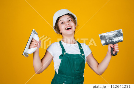 kid with helmet holding spatula. kid bricklayer masonry worker with helmet and trowel putty knife. house renovation. happy girl working with spatula. small builder using putty knife kid with helmet holding spatula. kid bricklayer masonry worker with helmet and trowel putty knife. house renovation. happy girl working with spatula. small builder using putty knife 112641251