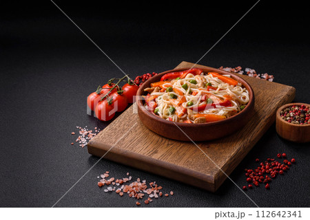 Delicious rice noodles or udon with chicken, carrots, pepper, salt, spices and herbs Delicious rice noodles or udon with chicken, carrots, pepper, salt, spices and herbs 112642341