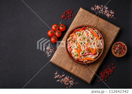 Delicious rice noodles or udon with chicken, carrots, pepper, salt, spices and herbs Delicious rice noodles or udon with chicken, carrots, pepper, salt, spices and herbs 112642342