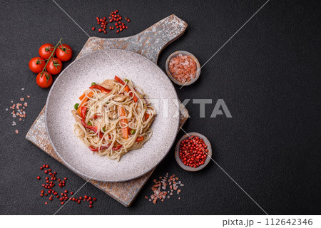 Delicious rice noodles or udon with chicken, carrots, pepper, salt, spices and herbs Delicious rice noodles or udon with chicken, carrots, pepper, salt, spices and herbs 112642346