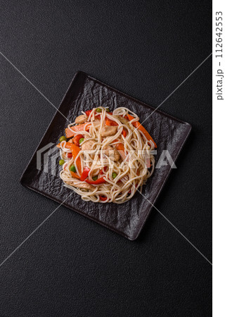 Delicious rice noodles or udon with chicken, carrots, pepper, salt, spices and herbs Delicious rice noodles or udon with chicken, carrots, pepper, salt, spices and herbs 112642553