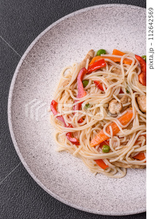 Delicious rice noodles or udon with chicken, carrots, pepper, salt, spices and herbs Delicious rice noodles or udon with chicken, carrots, pepper, salt, spices and herbs 112642569