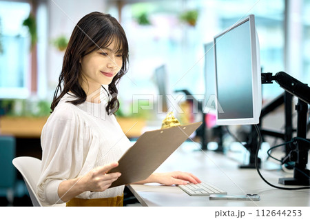 オフィスでデスクワークするビジネスウーマン 112644253