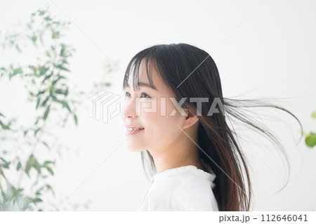 オーガニックや自然なイメージの緑がある若い女性の髪がなびく美容イメージ　ヘアケアやスキンケアイメージ 112646041