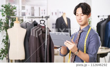 タブレットを手にするアパレルデザイナー タブレットを手にするアパレルデザイナー 112646292