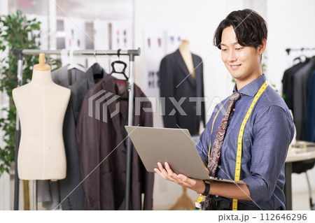 ノートPCを手にする若いファッションデザイナー 112646296