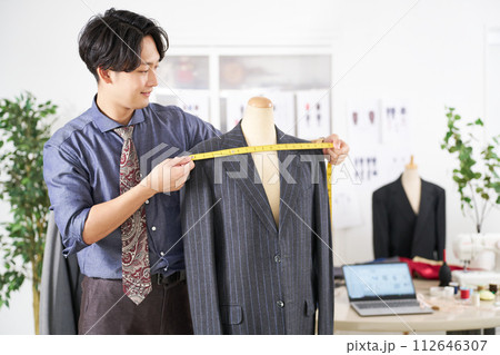 メジャーでサイズを測る若い男性スタイリスト 112646307