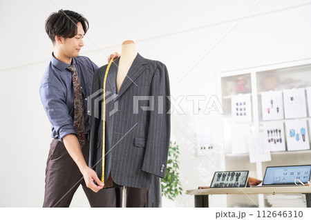 メジャーでサイズを測る若い男性スタイリスト 112646310