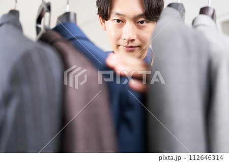 スーツをチェックする若い男性 112646314