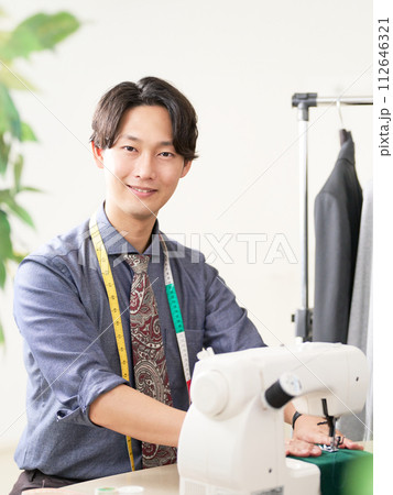 ミシンを使って仕事をする若い男性ファッションデザイナー ミシンを使って仕事をする若い男性ファッションデザイナー 112646321