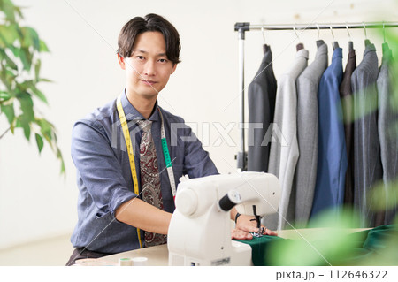 ミシンを使う若い男性デザイナー 112646322