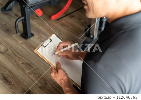 スポーツジムでカウンセリング・問診・アンケートをとるジムスタッフの手元 112646565