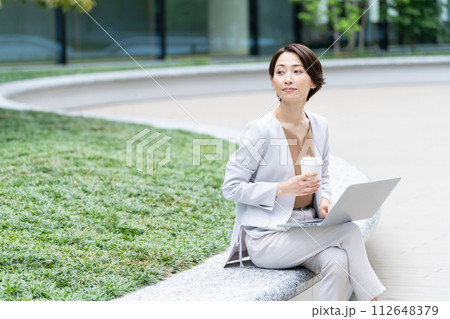 コーヒーを飲みながらパソコンを見るビジネスウーマン コーヒーを飲みながらパソコンを見るビジネスウーマン 112648379
