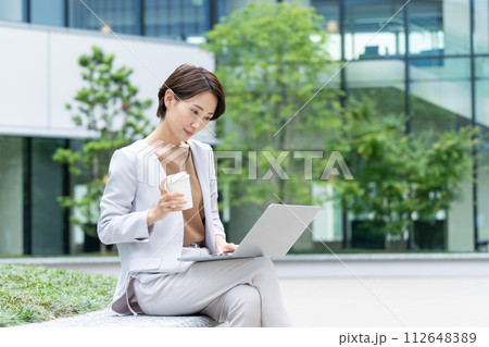 屋外でパソコンを使うビジネスウーマン 112648389