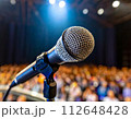 ライトがあたるステージに立つ一本のマイク 112648428