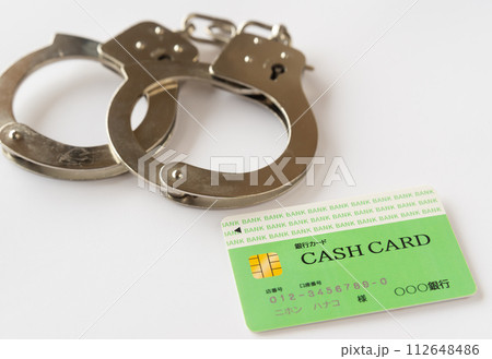 手錠とキャッシュカード　カード犯罪　特殊詐欺　犯罪イメージ　金融犯罪　違法行為　不正利用 112648486