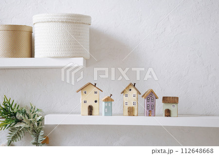 Wooden miniature houses on white shelf. 112648668
