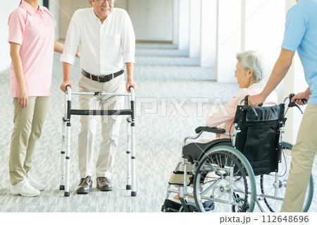 車いすの高齢者と介護する若いヘルパー 車いすの高齢者と介護する若いヘルパー 112648696