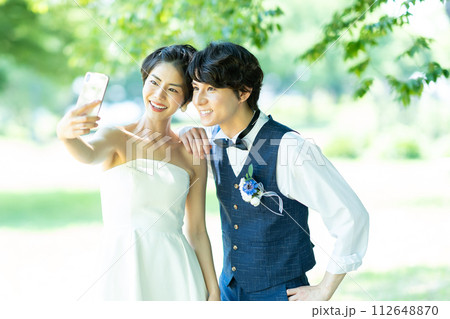 スマホで写真を撮る新郎新婦 スマホで写真を撮る新郎新婦 112648870