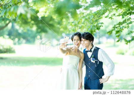スマホで写真を撮る新郎新婦 112648876