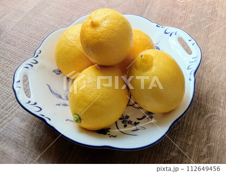 テーブルの上の洋食器に盛り付けた国産レモン テーブルの上の洋食器に盛り付けた国産レモン 112649456