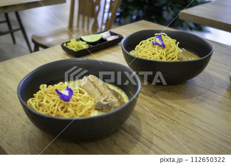 Thai noodles Khao Soi, spicy curry with seasoning on table Thai noodles Khao Soi, spicy curry with seasoning on table 112650322