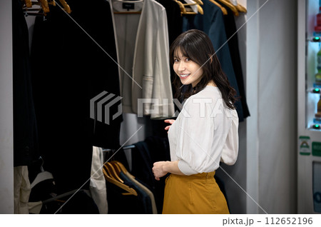 オフィスのクロークで服を取るビジネスウーマン オフィスのクロークで服を取るビジネスウーマン 112652196