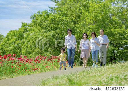 ポピーの咲く公園を歩く3世代家族 112652385