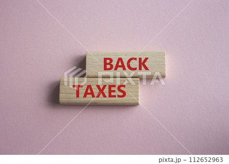 Back Taxes symbol. Concept word Back Taxes on wooden blocks. Beautiful pink background. Business and Back Taxes concept. Copy space 112652963