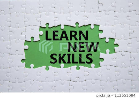 Learn new skills symbol. Concept words Learn new skills on white puzzle. Beautiful green background. Business and Learn new skills concept. Copy space. 112653094