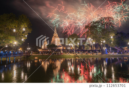 Fireworks celebration of Loy Krathong at Sukhothai Historical Park festival, buddha pagoda stupa in a temple, Sukhothai, Thailand. Thai buddhist temple architecture at night. Tourist attraction. Fireworks celebration of Loy Krathong at Sukhothai Historical Park festival, buddha pagoda stupa in a temple, Sukhothai, Thailand. Thai buddhist temple architecture at night. Tourist attraction. 112653701