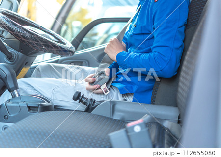 シートベルトを装着する男性トラックドライバー 112655080