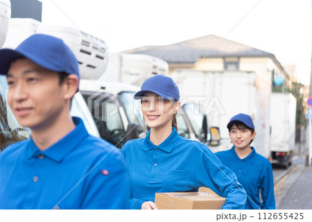 荷物を運ぶ男女のトラックドライバー 荷物を運ぶ男女のトラックドライバー 112655425